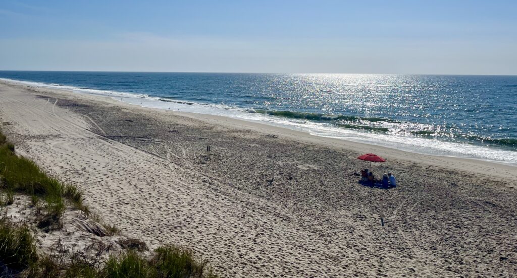 a sandy beach with a red umbrella (MyCoast AI)