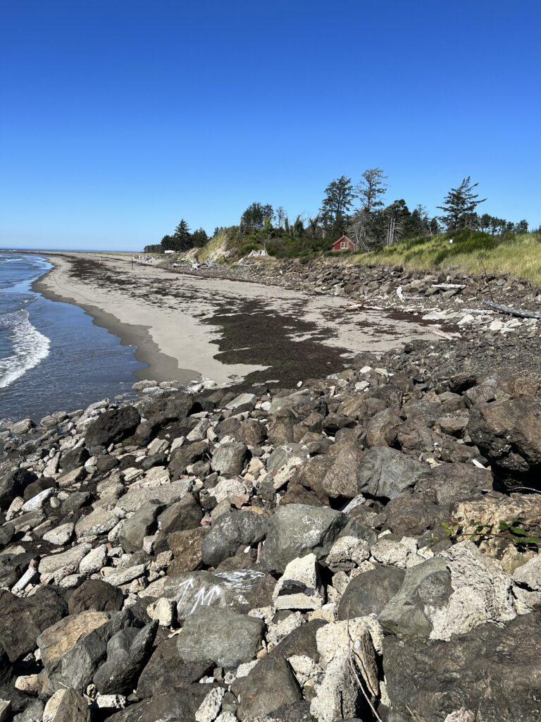 a rocky beach with a small house (MyCoast AI)