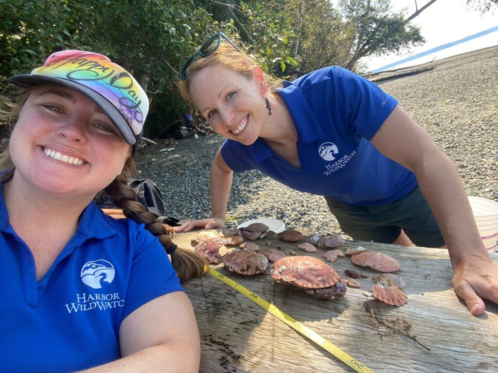 a couple of women smiling and standing next to a pond with rocks (MyCoast AI)