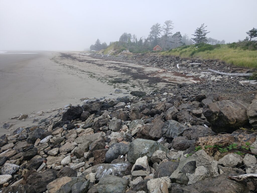 a rocky beach with a house in the distance (MyCoast AI)