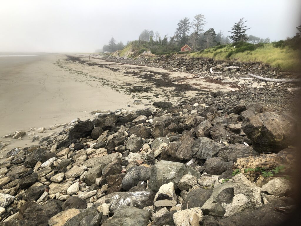 a rocky beach with a house in the distance (MyCoast AI)