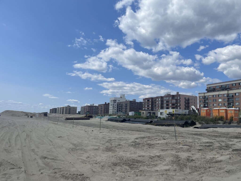 a sandy beach with buildings in the background (MyCoast AI)