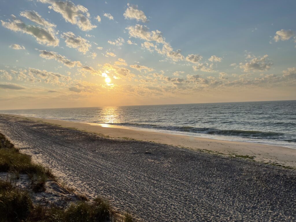a beach with the sun setting (MyCoast AI)