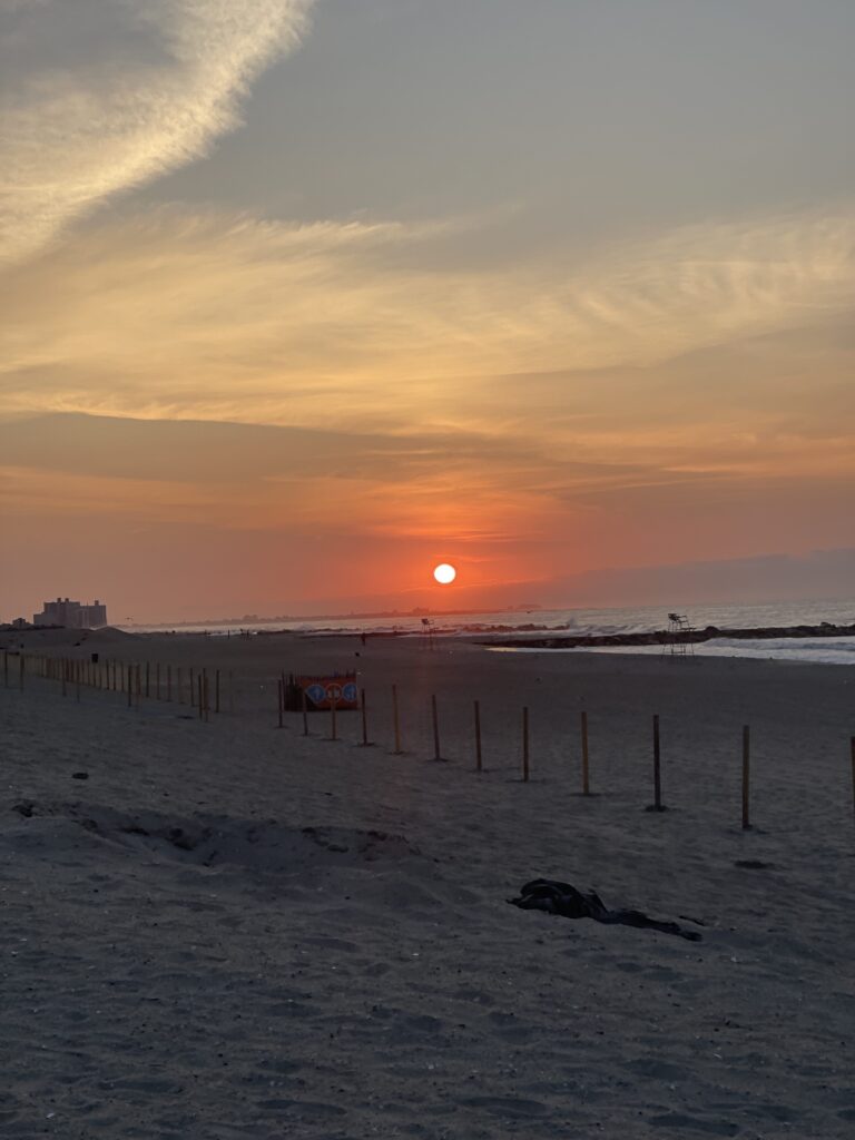 a beach with a fence and a sunset (MyCoast AI)