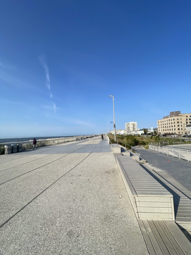 a walkway with a body of water and buildings in the background (MyCoast AI)