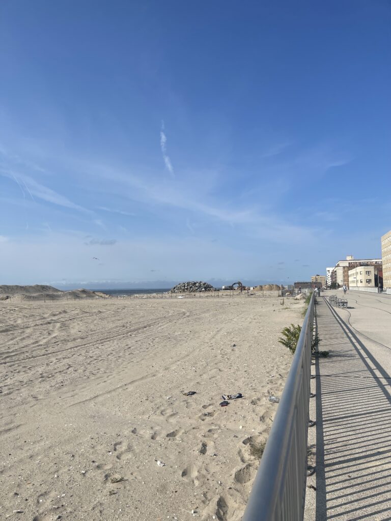a sandy beach with buildings and a fence (MyCoast AI)