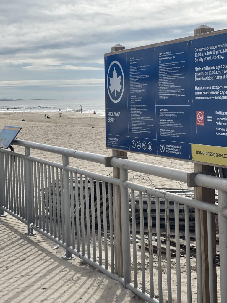 a sign on a railing at a beach (MyCoast AI)