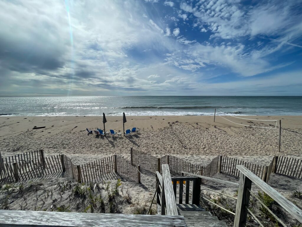 a beach with a fence and a body of water in the background (MyCoast AI)
