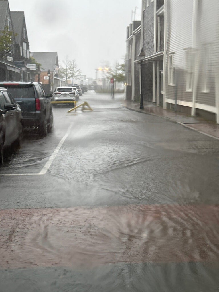a wet street with cars parked on the side (MyCoast AI)