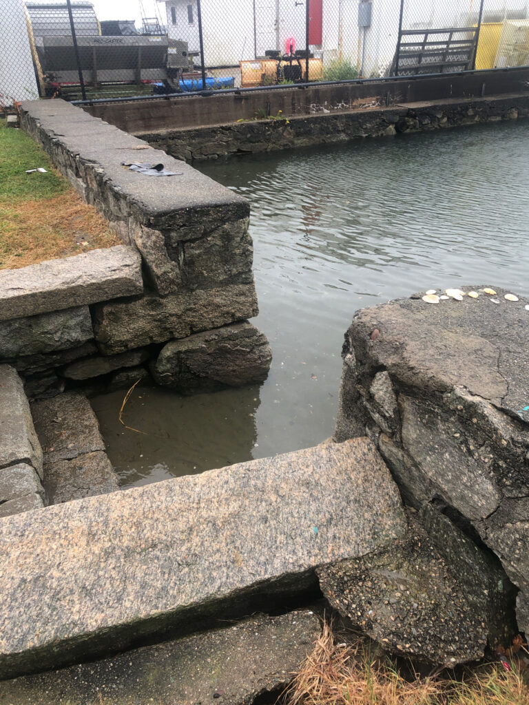 a body of water with rocks and a bridge in the background (MyCoast AI)
