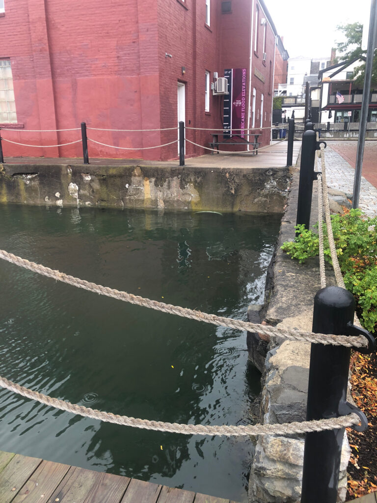 a canal with a brick building (MyCoast AI)