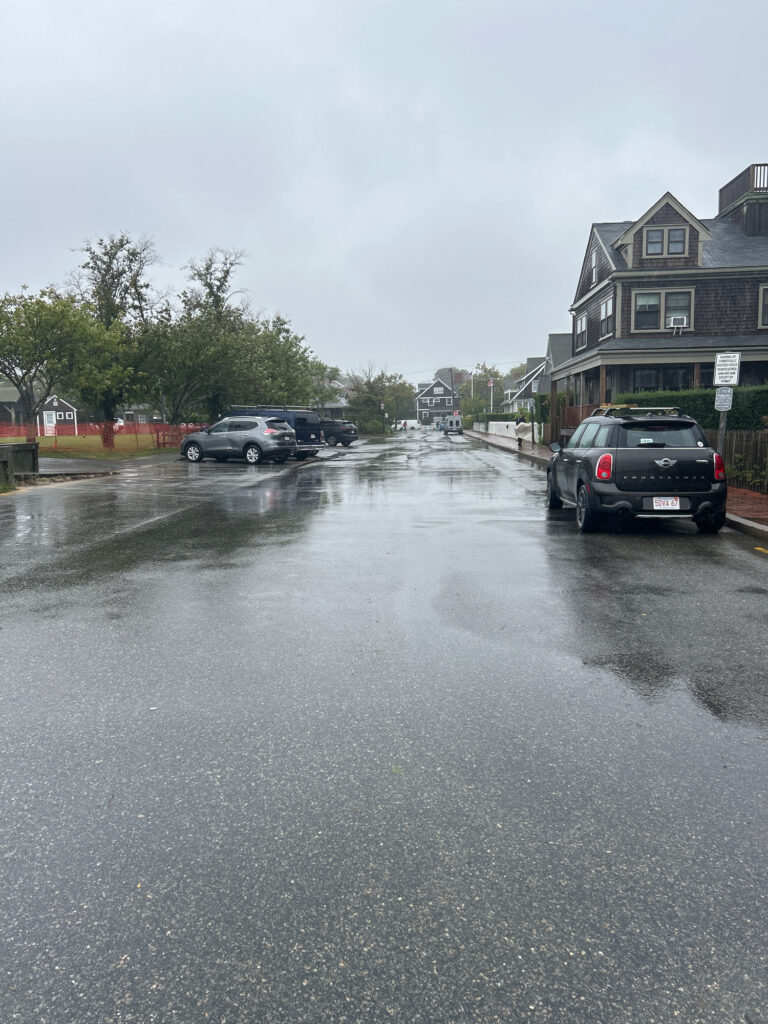 a wet street with cars parked on the side (MyCoast AI)