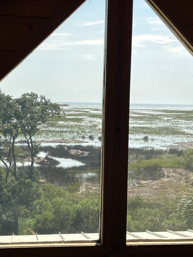 a view of a beach through a window (MyCoast AI)
