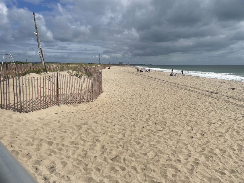 a sandy beach with a fence and a wooden post (MyCoast AI)