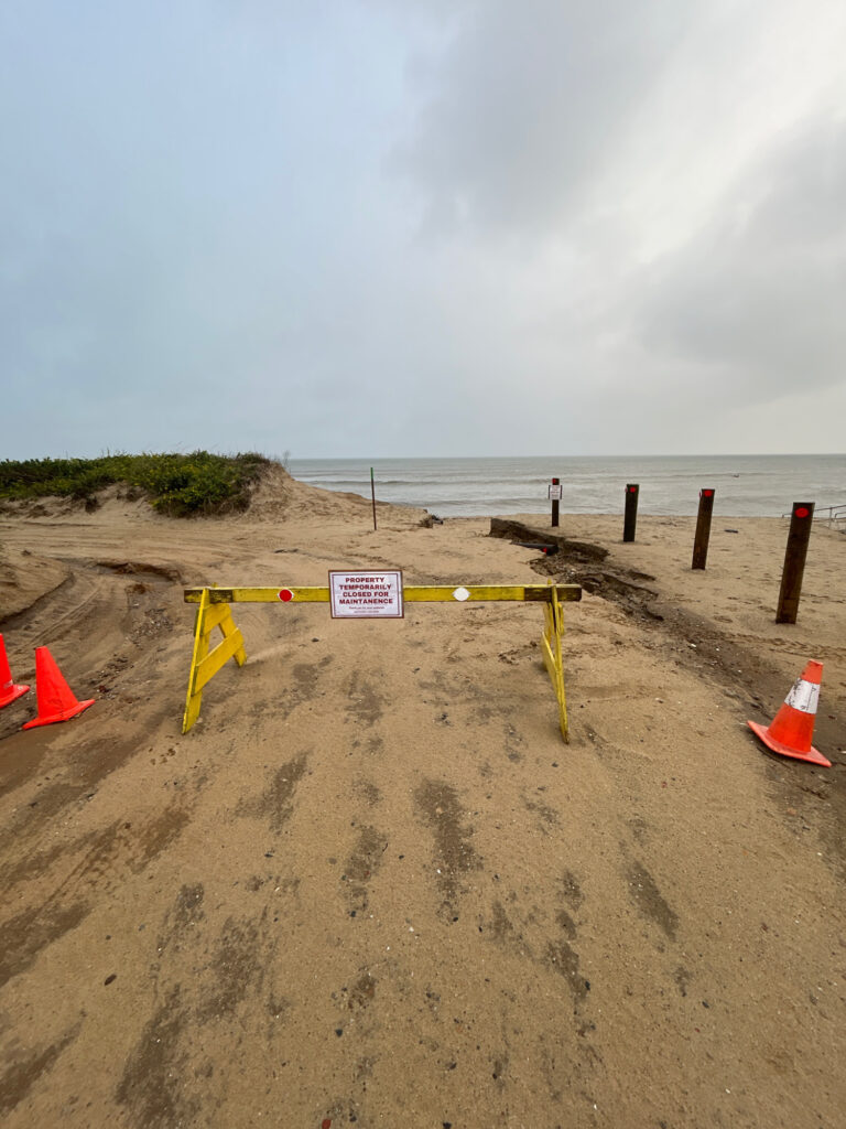 a beach with a sign and a fence (MyCoast AI)
