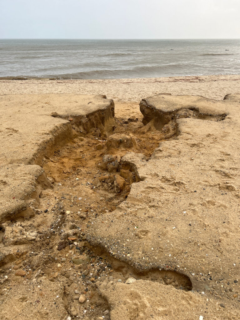 a sandy beach with rocks and water (MyCoast AI)