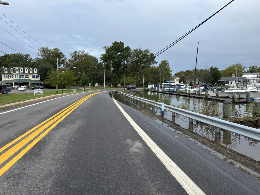 a road with cars on it next to a body of water (MyCoast AI)