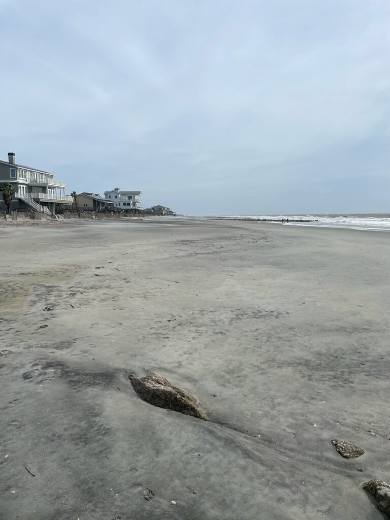 a sandy beach with buildings in the background (MyCoast AI)