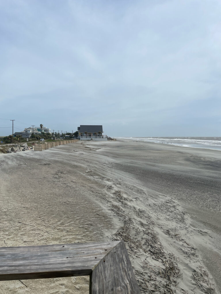 a sandy beach with a building in the distance (MyCoast AI)