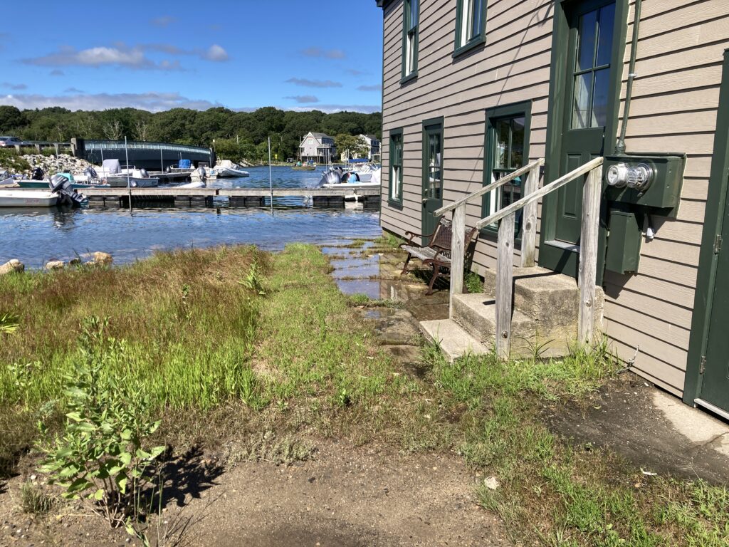 a house next to a body of water with boats in it (MyCoast AI)