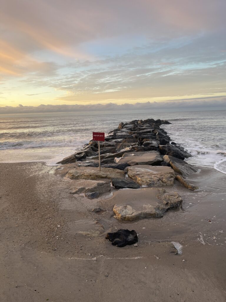 a beach with rocks and a sign (MyCoast AI)