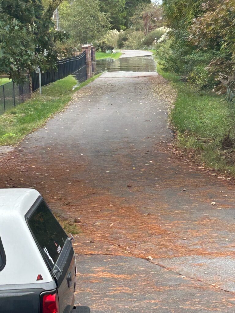 a road with a puddle on the side and a car parked on the side (MyCoast AI)
