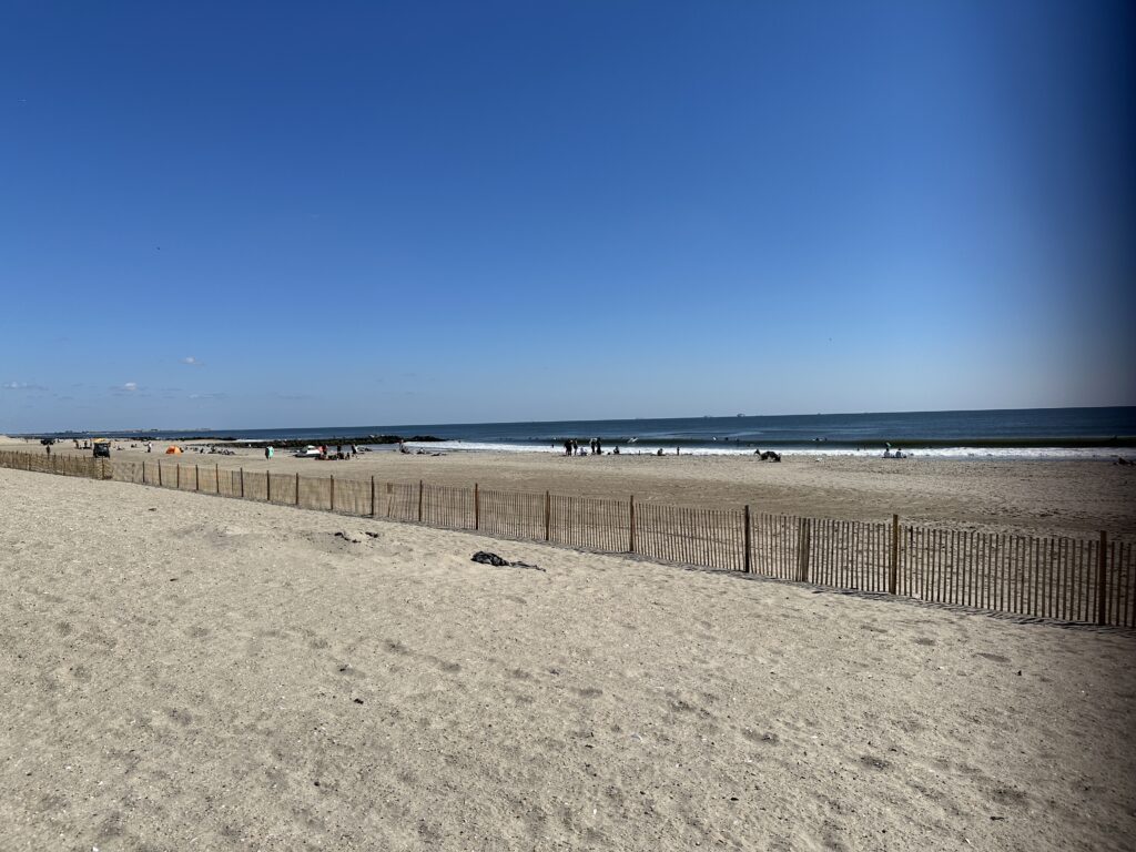 a beach with a fence and a body of water in the background (MyCoast AI)