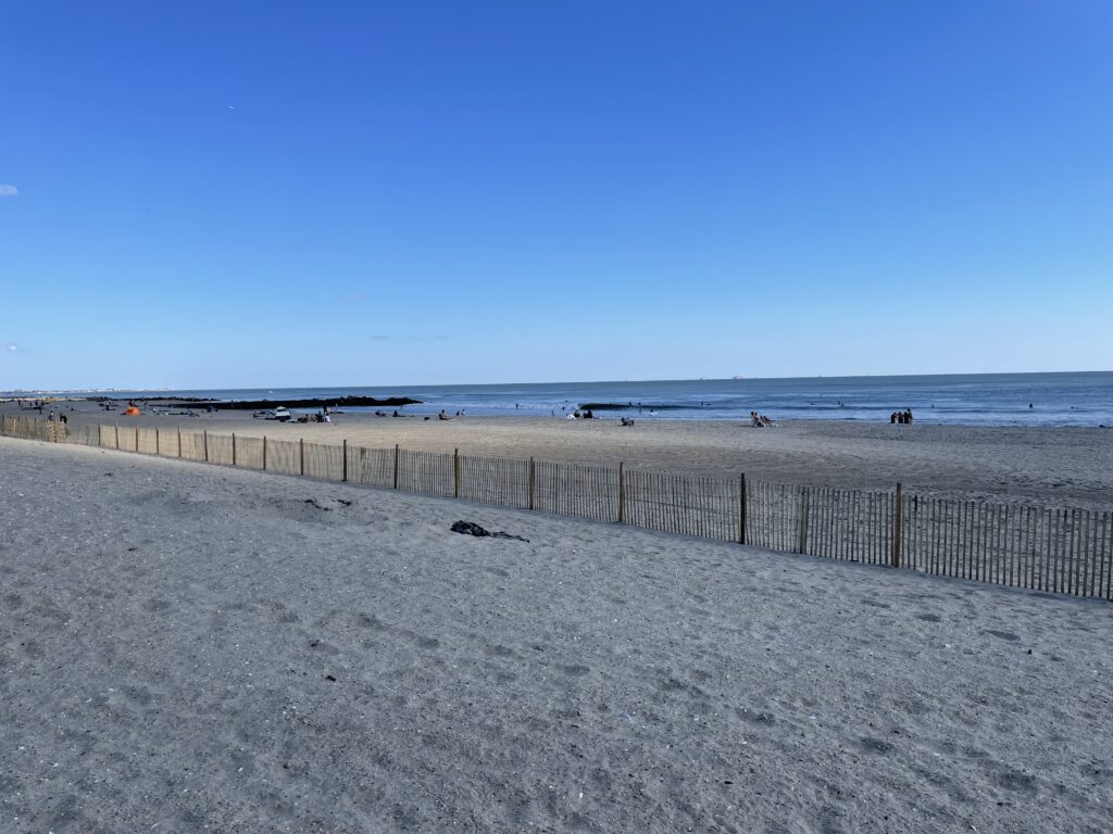 a beach with a fence and a body of water in the background (MyCoast AI)