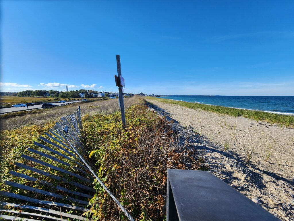 a fenced off area with a beach and water in the background (MyCoast AI)