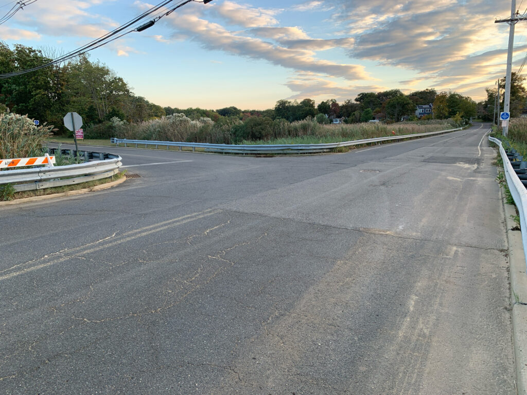 a road with a barrier and trees on the side (MyCoast AI)