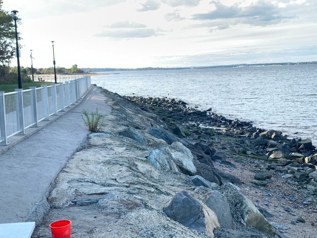 a rocky beach with a white fence (MyCoast AI)