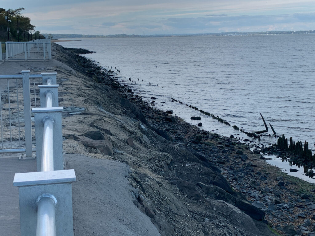 a rocky beach with a white fence (MyCoast AI)
