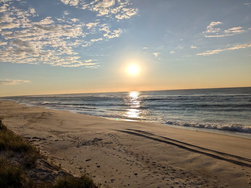 a beach with the sun setting (MyCoast AI)