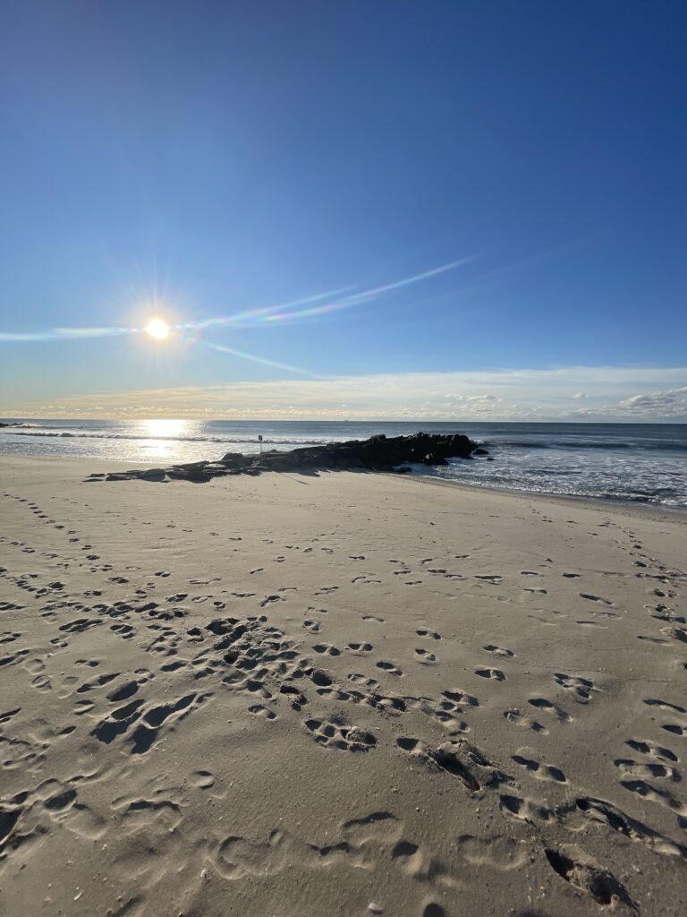 a sandy beach with the sun in the sky (MyCoast AI)