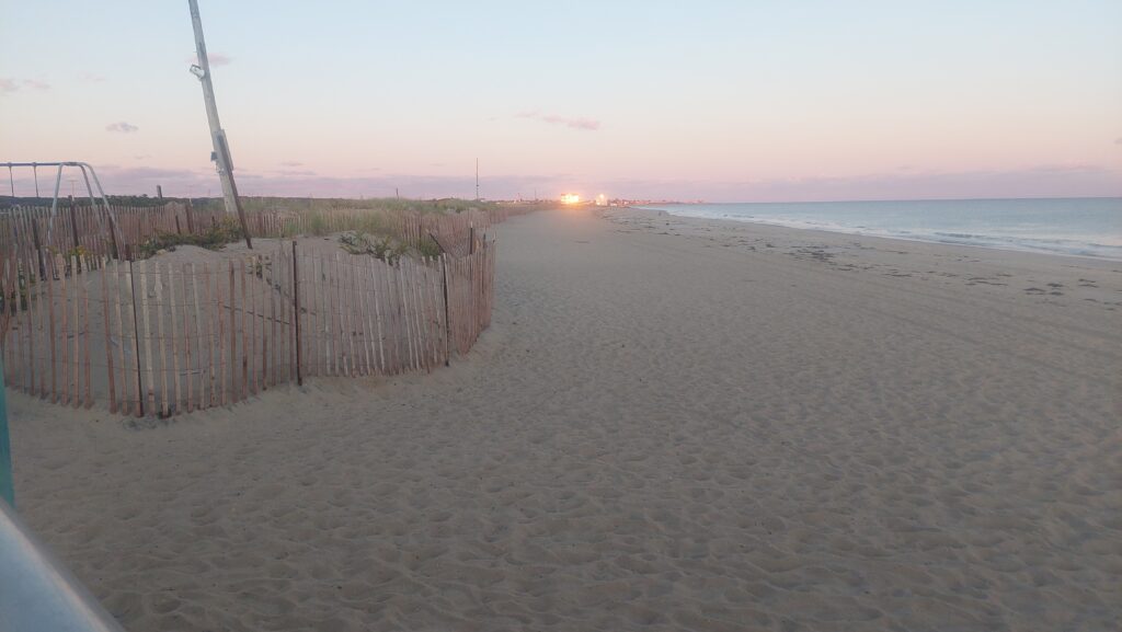 a sandy beach with a fence and a sunset (MyCoast AI)