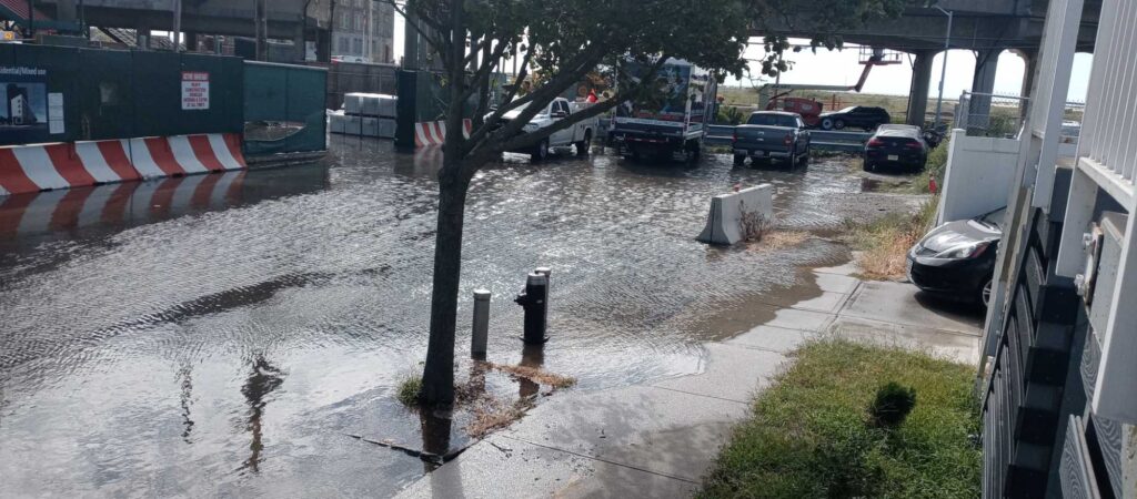 a flooded street with cars and a fire hydrant (MyCoast AI)