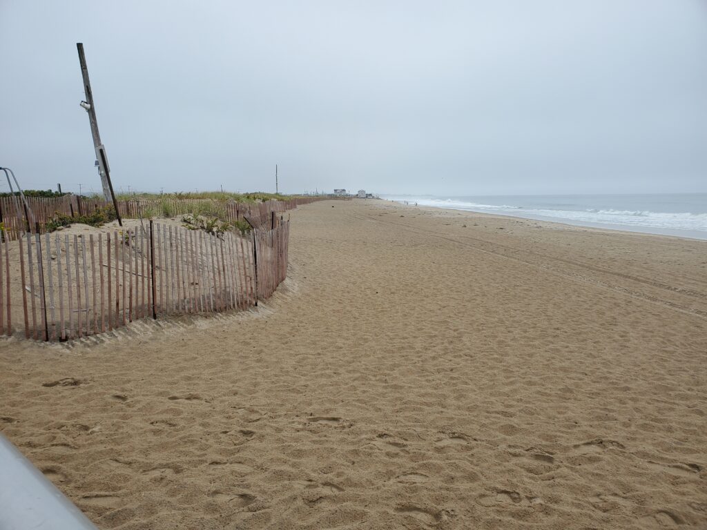 a sandy beach with a fence (MyCoast AI)