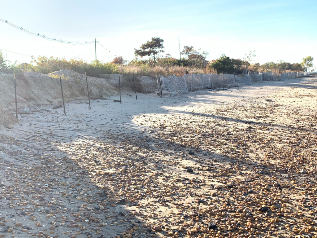 a dirt road with a fence and trees on the side (MyCoast AI)