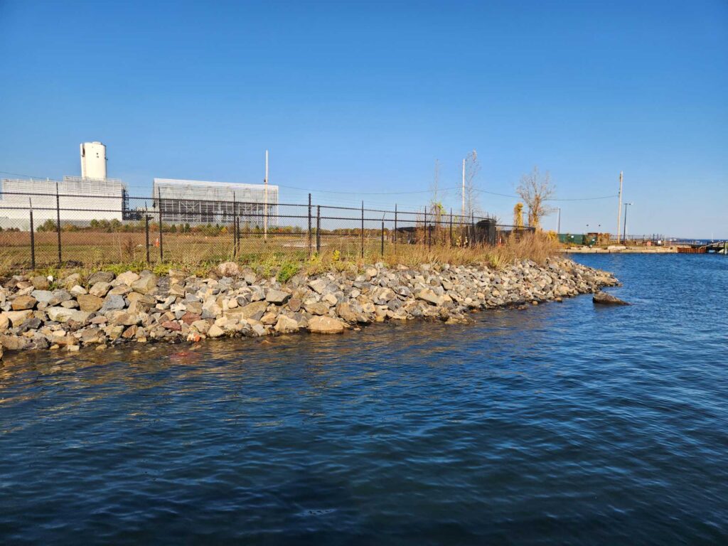 a body of water with rocks and a fence around it (MyCoast AI)