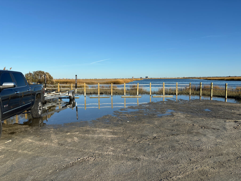 a body of water with a dock and a car parked on the side (MyCoast AI)