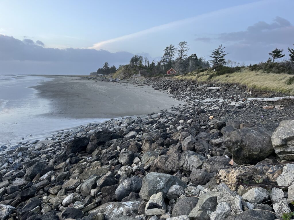 a rocky beach with a house in the distance (MyCoast AI)