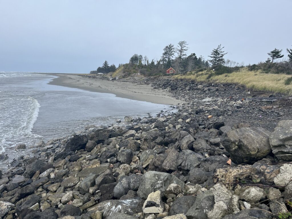 a rocky beach with a house in the distance (MyCoast AI)