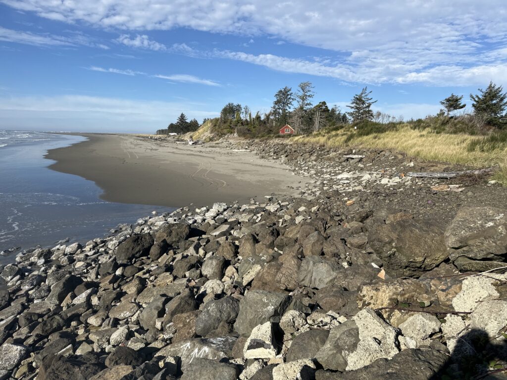 a rocky beach with a house in the distance (MyCoast AI)