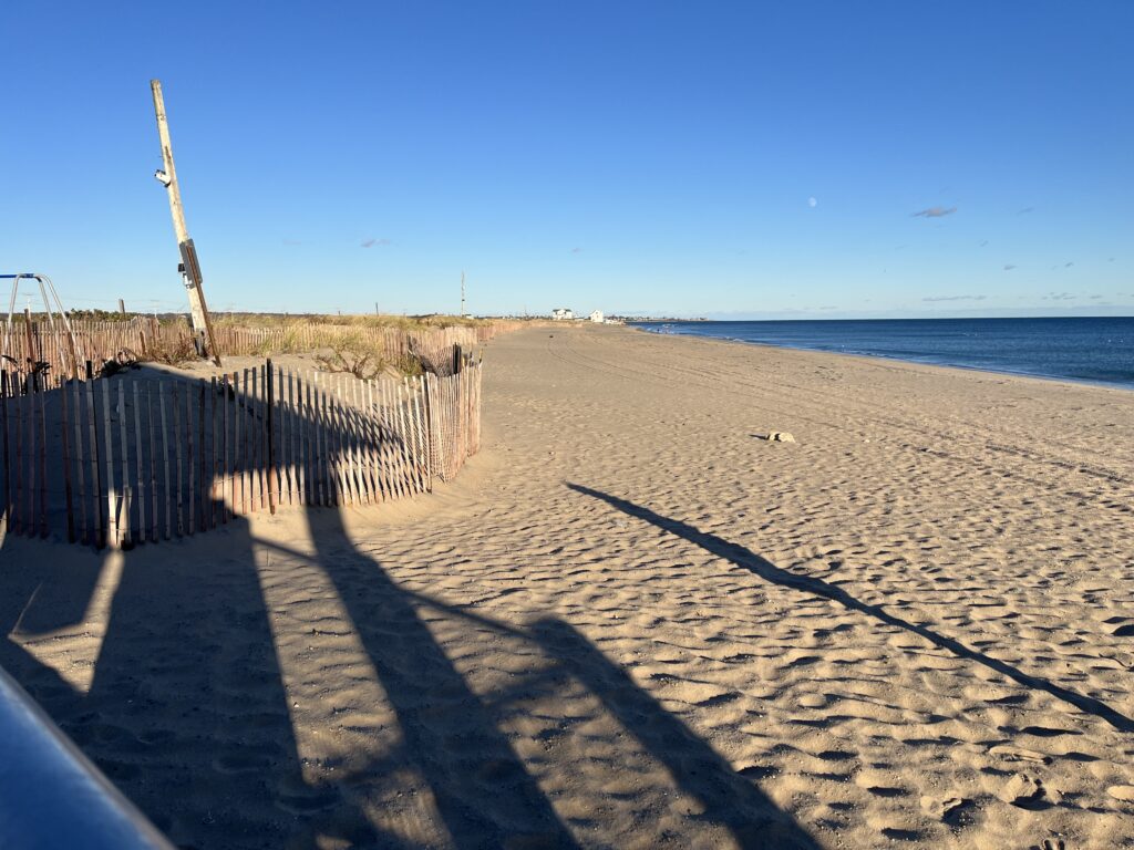 a sandy beach with a fence and a wooden post (MyCoast AI)