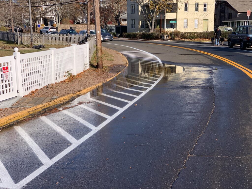 a road with a white fence and a white picket fence (MyCoast AI)