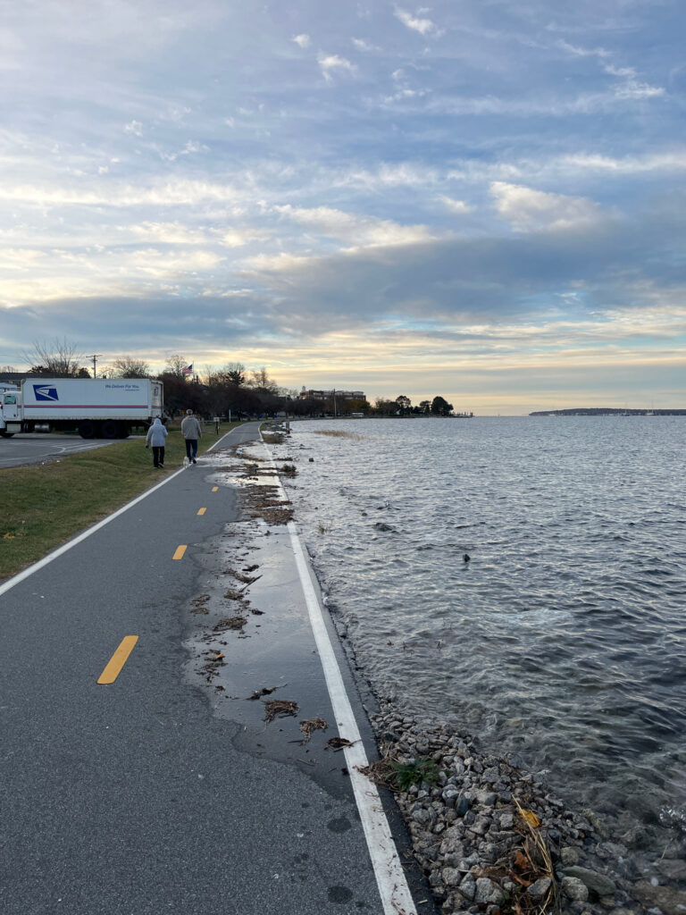 a road next to a body of water with people walking on it (MyCoast AI)