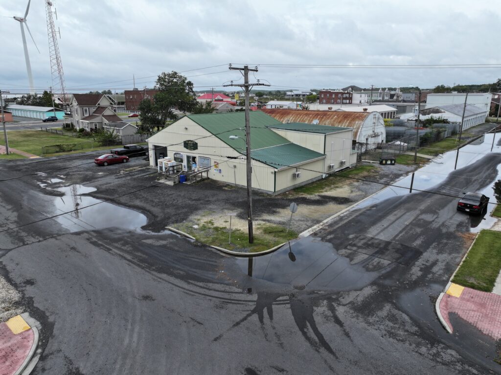 a road with a building on the side and a car on the road (MyCoast AI)