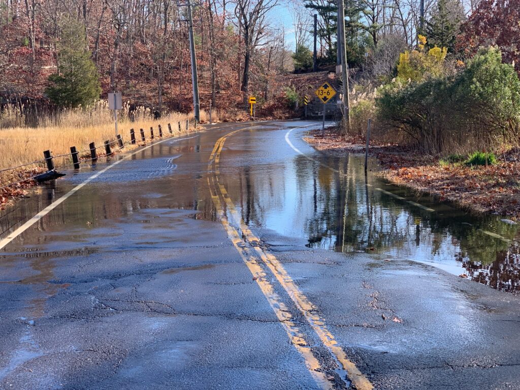 a flooded road with a yellow sign (MyCoast AI)