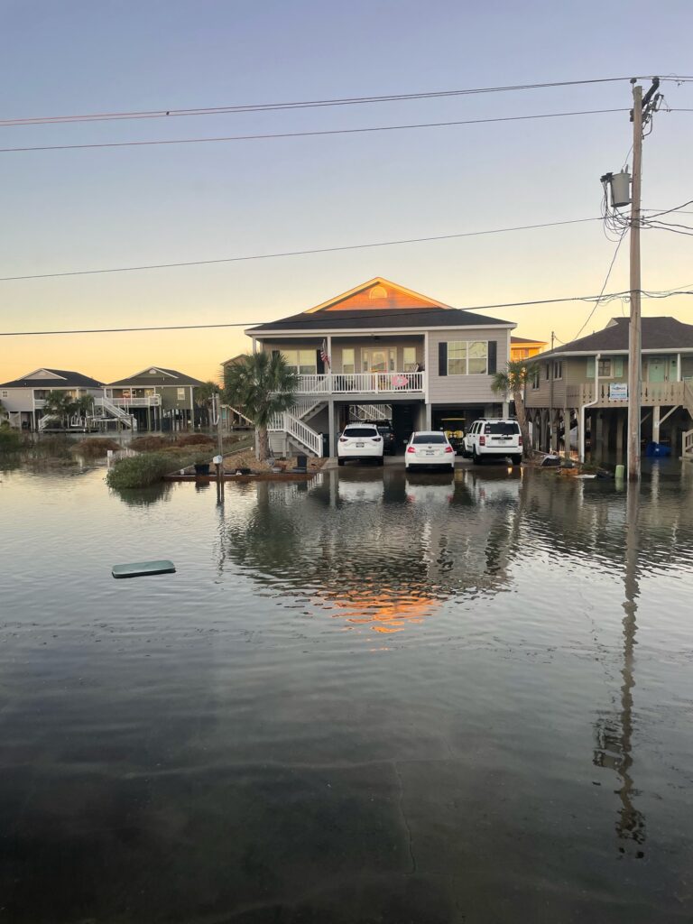 a flooded street with houses and cars (MyCoast AI)