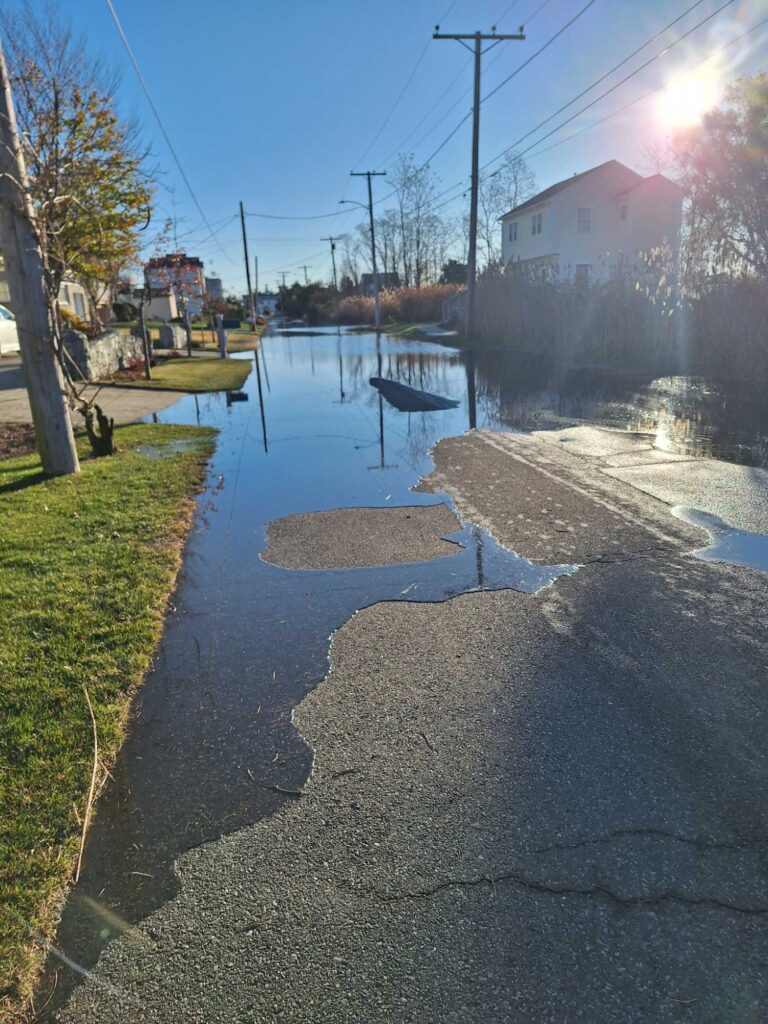 a wet road with a puddle on the side (MyCoast AI)